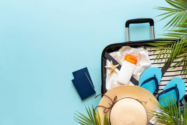 istock Open Suitcase with summer cloth, shoes and accessories on blue background. 1927790109