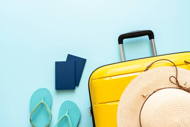 istock Suitcase, hat, passports and flip flops on blue background. 1927790112