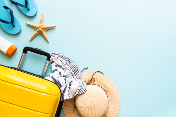 istock Suitcase, hat and flip flops on blue background. 1927790654