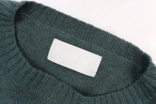 istock Blank white label on green cotton sweater close up 1927792776