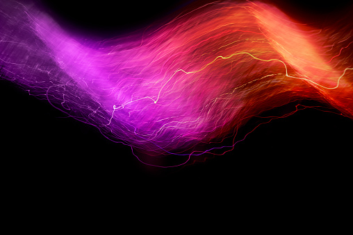 Abstract light swoosh background creating dynamic purple and red shapes by painting with light sources.