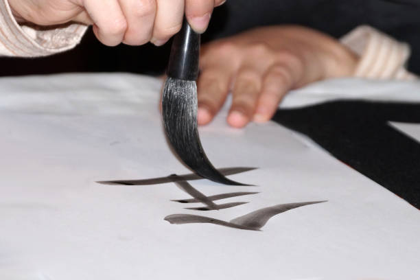 istock Brush drawing a hieroglyph with black ink on white rice paper 1927814256