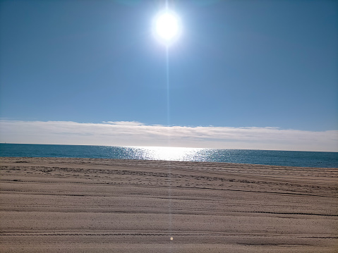 Primer sol de la mañana sobre el mar Mediterráneo en la playa del Maresme de Vilassar de Mar, Barcelona en verano. photo