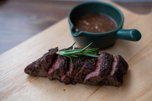 istock Medium rare sliced meat on wooden plate with sauce 1927834889