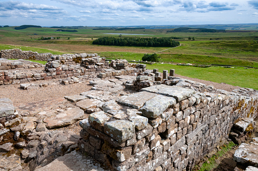 An image of Hadrian's Wall, a historic fortification in Northern England. This ancient structure, stretching across the rugged landscape, stands as a testament to Roman engineering and a poignant reminder of the past, weaving through the rolling hills and green fields of the English countryside.