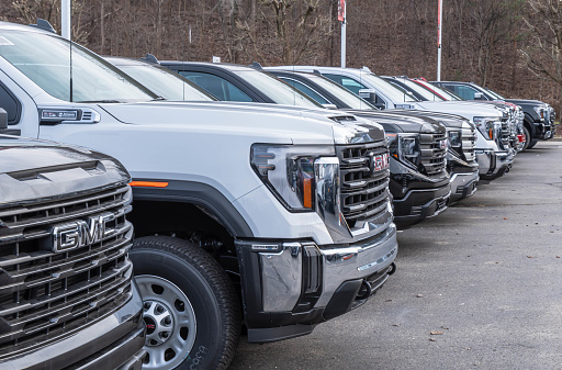 Monroeville, Pennsylvania, USA December 25, 2023 A line of new GMC four door pickup trucks for sale at a dealership on a winter day