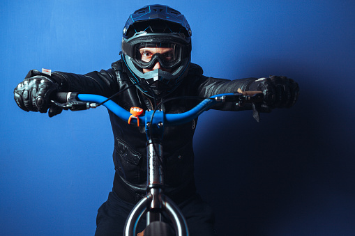 Man with helmet on stunt bicycle, studio shot