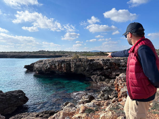 Man pointing at landscape beach and rocks