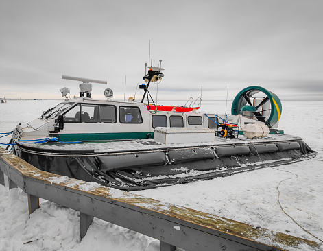 Coast and border guards hovercraft parked on an icy shore of frozen lake in Lithuania