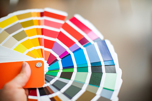 Interior designer working with color palette. Closeup of hand with color palette