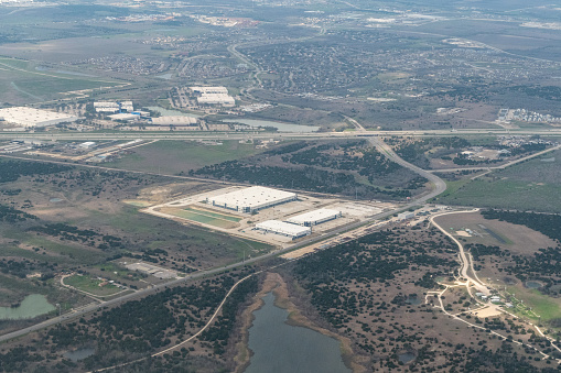 Aerial view of the Austin area featuring Amazon shipping Warehouse VTX9 and the Applied Materials Complex alongside Route 290 outside of Austin Texas