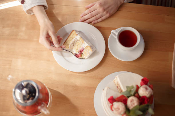 istock women's hands cake and tea in a Cup and teapot on the table 1927932183