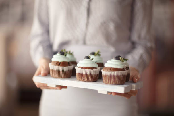 istock women's hands and cupcakes with blueberries on the Board 1927932186