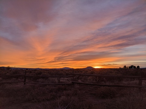 A majestic cloudscape horizon in the high desert with Table Rock in the background and a homestead in the distance