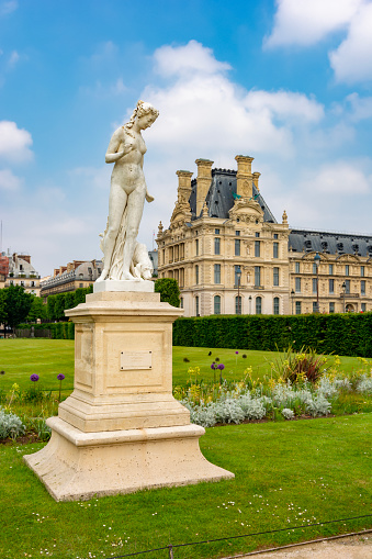 Paris, France - May 2019: Statue of Nymph in Tuileries garden and Louvre palace