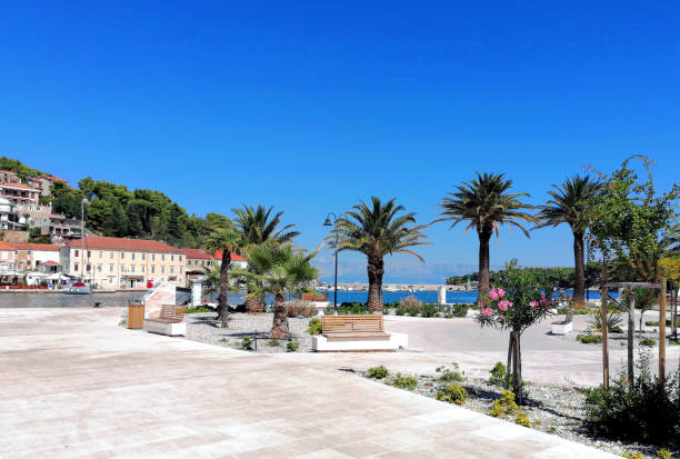 View of the beautiful new waterfront promenade of town Jelsa on the Hvar island on a sunny day in summer with deep blue sky. Island Brac in the background.
