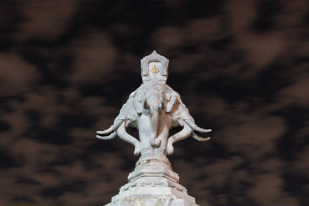 Marble statue with elephant heads, Bangkok, Thailand. Cloudy night sky in background.