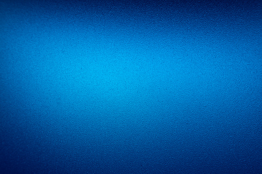 Close up of textured frosted blue glass. Suitable for background use.