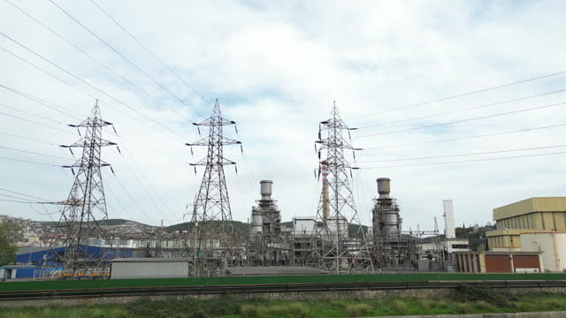 High voltage towers at industrial zone. Power lines against the sky.