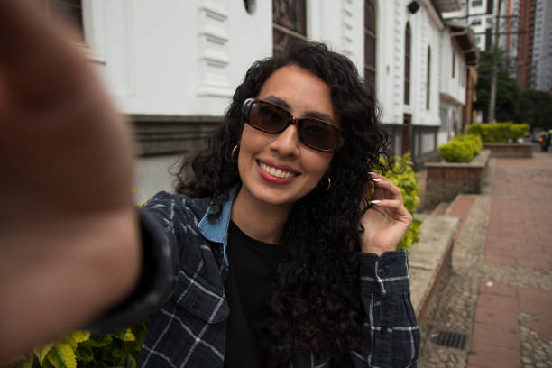 istock Young Latina taking a photo with her cell phone 1928116895