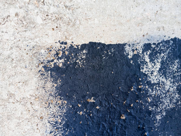 istock Dirty cement wall with black paint stains. Abstract black paint grunge background with copy space. 1928120117