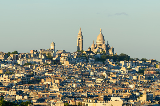 This landscape photo was taken, in Europe, in France, in ile de France, in Paris, in summer. We see the Basilica of the Sacred Heart on the Montmartre hill, under the Sun.