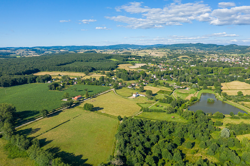 This landscape photo was taken in Europe, in France, in Burgundy, in Nievre, in Saint-Honoré-les-Bains, near Chateau Chinon, in summer. We see a traditional village, a former seaside resort in the middle of the countryside, under the sun.