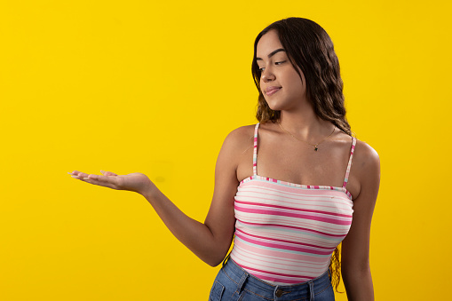 young woman wearing glasses and a tank top on a yellow background