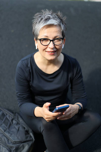 istock A mature woman in sportswear using a smartphone outdoors, combining technology with an active and healthy lifestyle in her retirement years. 1928302588