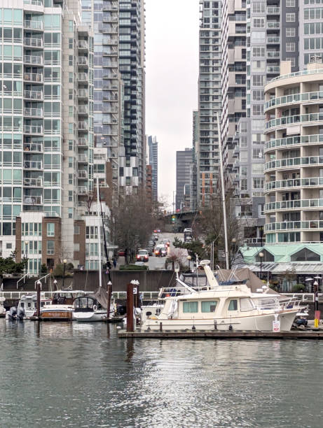 Vancouver, Canada - December 21, 2023: Looking north from Granville Island to downtown traffic on Howe Street. Modern residential buildings and businesses near Beach Avenue line the False Creek north waterfront. Winter morning with overcast skies.