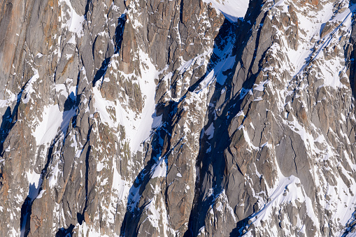 This landscape photo was taken in Europe, in France, Rhone Alpes, in Savoie, in the Alps, in winter. We see the rocky mountains of the Mont Blanc massif, under the Sun.