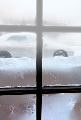 Fogged-Up Indoor Window with Snowy Car Outside