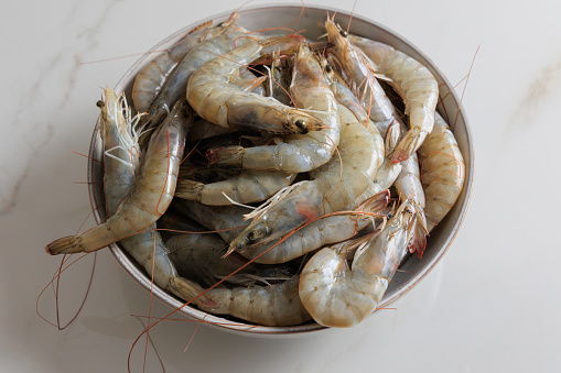 Burned shrimp Or Grilled shrimp and seafood sauce is very tasty on a white plate on white wood background.
