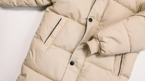 istock Childrens winter jacket. Stylish childrens beige warm down jacket isolated on white background. Winter fashion 1928368742
