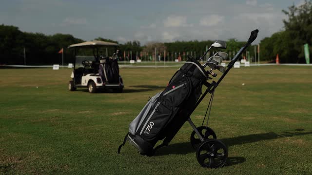 Shot of golf trolley bag and golf car on a golf course