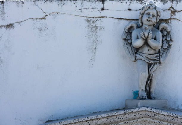 Angel statues looking at the sky on the top of the tombstone