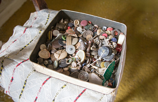 An old box of random buttons in a bedroom
