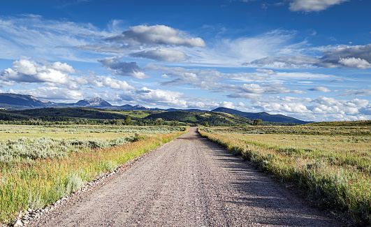 Deserted gravel dirt road in the Grand Teton National Park facing south to the Bridger-Teton National Forest, Gros Ventre Wilderness area outside of Jackson Wyoming.