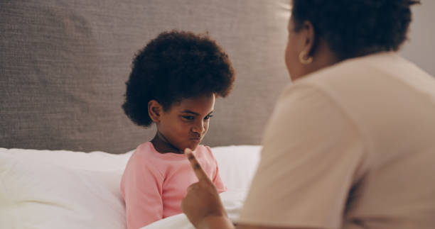 母親、しつけ、女児は寝室で、悪い行動を止めるために厳格な親が話したり、接地したりします。怒っている、家族や欲求不満のアフリカのお母さんは、家庭で罰でいたずらな子供を叱る - hand sign stop gesture talking discussion ストックフォトと画像