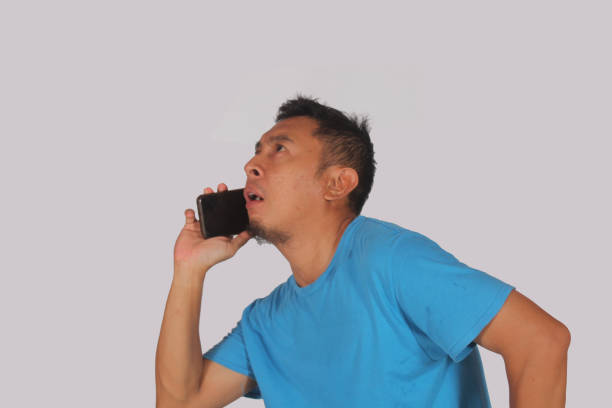 Photo of an Indian businessman trying to conduct a conversation on an antiquated \