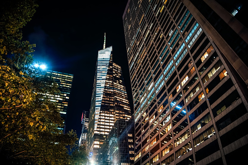 Street level view from West 42nd Street to the Grace Building and the Bank of America Tower at night in Manhattan, NYC.