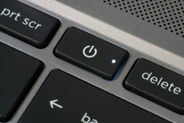 Close up of laptop power button with an illuminated LED.