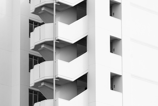 High level living apartment stairway that located outside the building in grayscale.