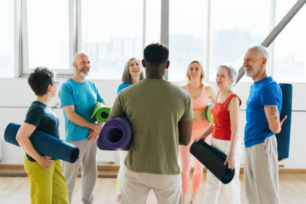istock Group of senior athletes raise hands to ceiling at workout 1928849696