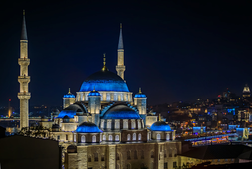 Evening cityscape of the Historic Peninsula with Yeni Cami or New Mosque at night after sunset in Istanbul, Turkey