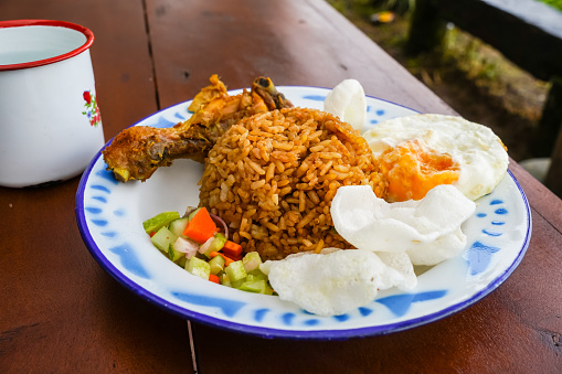 Javanese village style fried rice, with fried egg, crackers and chopped vegetables