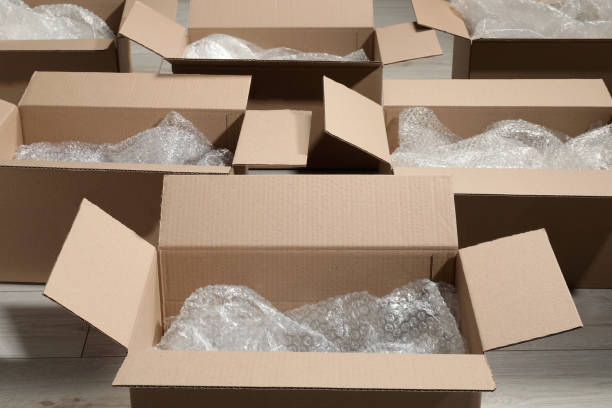 istock Many open cardboard boxes with bubble pack on white wooden floor 1928947514