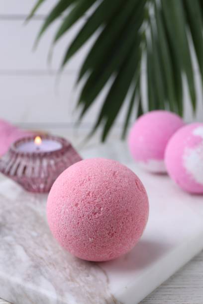 istock Beautiful aromatic bath bombs on white wooden table, closeup. Space for text 1928988693