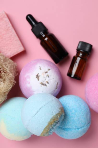 istock Bath bombs, loofah sponge, soap bar and bottles on pink background, flat lay 1928988694