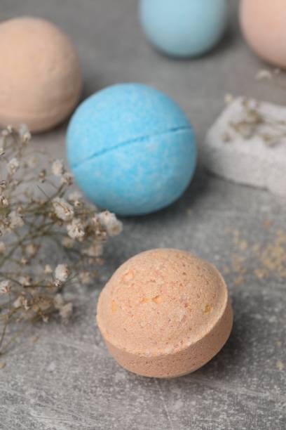 istock Beautiful aromatic bath bombs and gypsophila flowers on light grey table 1928989731